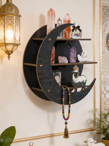Black crescent moon-shaped wooden wall shelf displaying crystals and spiritual ornaments