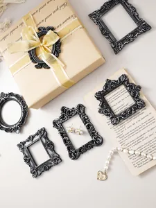 Ornate vintage resin picture frames in black and silver used as creative photography props