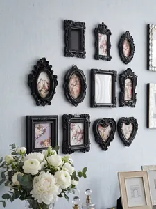 Collection of ornate vintage black mini magnetic photo frames on a light blue wall decor