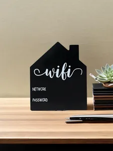 Detail of house-shaped black WiFi password sign on a wooden desk with succulent