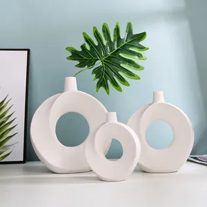 Minimalistische weiße Keramikvasen im Donut-Design in drei Größen mit grünem Blatt