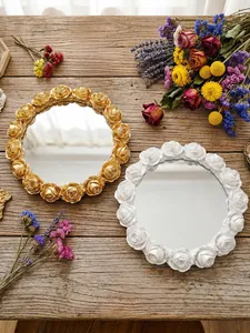 Macro view of gold and white rose embossed resin trays on a rustic wooden decorative setting