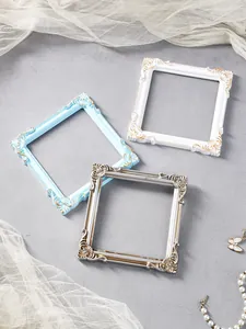 Close-up of three ornate European vintage relief square frames in blue, white, and silver