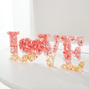 Decoratieve LOVE letters van kunsthars met roze schelpen en goudfolie voor bruiloften