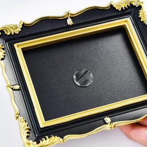 Close-up detail of a retro black and gold baroque style photo frame for DIY wall decor.