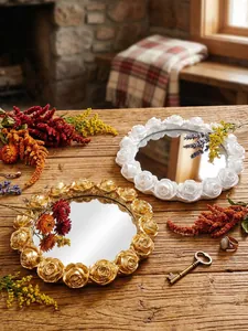Macro view of gold and white rose embossed resin trays on a rustic wooden table