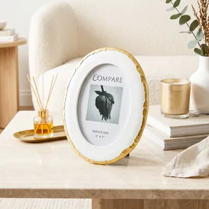 Elegante cornice ovale in resina con bordi dorati in un ambiente domestico raffinato