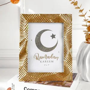 Detailansicht eines goldenen gestreiften Fotorahmens auf einem eleganten Tischdeko