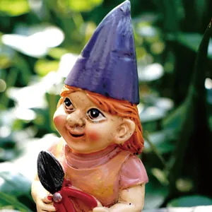 Macro detail shot of a mini garden gnome girl figurine holding red garden shears outdoors