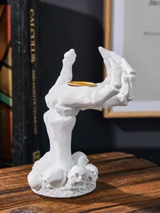 Gedetailleerd overzicht van witte skelet hand kandelaar met een gouden inzetstuk
