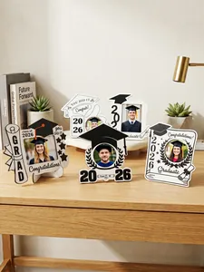 Assortimento di cornici in legno a tema laurea esposte su una scrivania in legno naturale