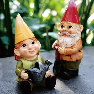 Close-up of miniature garden gnome figurines holding a watering can and garden shears