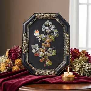 Vintage octagonal black resin frame with gold floral detail on burgundy velvet cloth