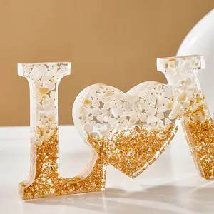 Detailweergave van hars LOVE-letters met witte stenen en goudfolie kleurverloop