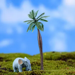 Detailed view of miniature coconut tree and blue elephant on moss micro-landscape.