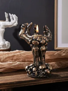 Detail van bronzen skelet hand kandelaar met een gedetailleerde schedel basis