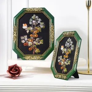 Close-up of vintage octagonal green resin frames with gold floral accents