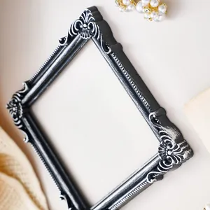Macro view of vintage black ornate frame with silver relief details for jewelry props