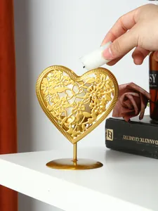 Vue détaillée d'un bougeoir romantique en fer doré sculpté en forme de cœur évidé