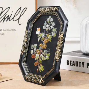 Detail of European retro octagonal resin photo frame with golden floral relief pattern
