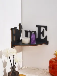 Close-up detail view of black wooden 'HOME' bird corner shelf with candle and crystal decor