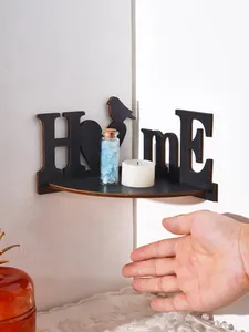 Close-up of decorative black wooden HOME corner shelf with bird design and candles