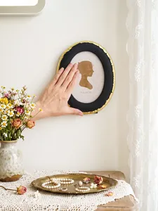 Cornice per foto ovale vintage in resina nera e oro in un ambiente lussuoso stile francese
