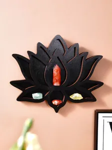 Vue détaillée d'une étagère à cristaux en bois en forme de lotus noir sur un mur rose