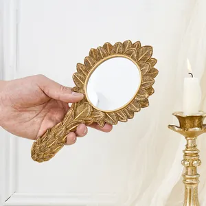 Vintage French style golden resin hand mirror with decorative oval leaf pattern frame