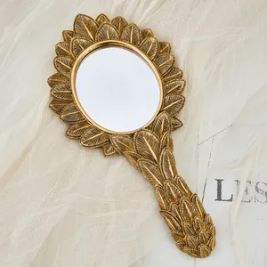 Vintage French gold resin hand mirror with ornate leaf pattern and decorative handle