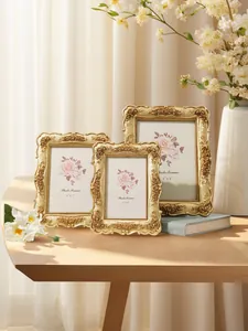 Detailed view of three vintage gold photo frames with intricate rose carvings