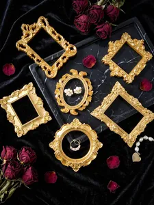 Cadres dorés vintage sur velours noir avec roses séchées et bijoux pour photographie