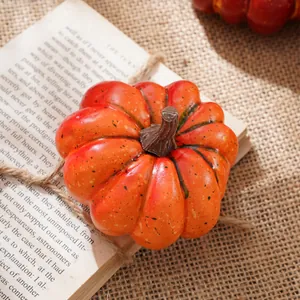 Primo piano dettagliato di una zucca artificiale arancione su un vecchio libro per decoro