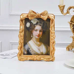 Detailansicht eines verzierten goldenen Vintage-Fotorahmens mit dekorativer Schleife.