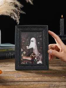 Detailaufnahme eines schwarzen Halloween-Fotorahmens aus Harz mit 3D-Geist-Motiv beim Lesen