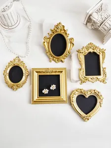 Macro view of ornate European-style mini gold photo frames used for jewelry display props