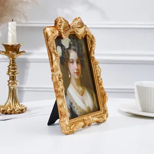 Verzierter europäischer Vintage-Gold-Fotorahmen mit dekorativer Schleife und klassischem Porträt