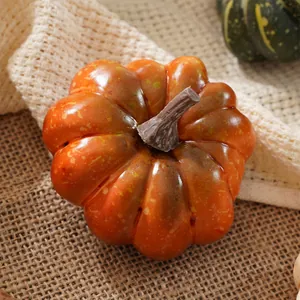 Primo piano di una zucca realistica in schiuma verniciata su sfondo di iuta rustico.