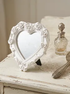 Eleganter herzförmiger Desktop-Schminkspiegel mit aufwendigen weißen Rosenrelief-Schnitzereien.