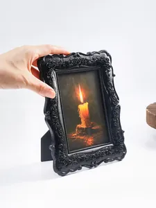 Vista detallada de marco de fotos gótico negro con relieve de rosas y arte de vela decorativo