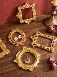 Vue détaillée de cadres photo vintage dorés utilisés comme accessoires de présentation bijoux.