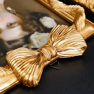 Nahaufnahme eines goldenen Vintage-Fotorahmens mit aufwendigem 3D-Schleifen-Reliefmuster