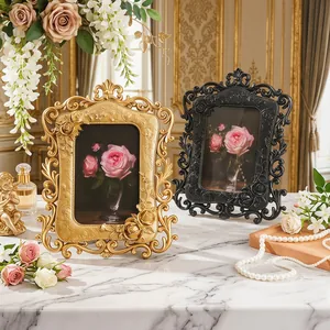 Pareja de marcos de fotos vintage de resina con relieve de rosas en mesa de mármol