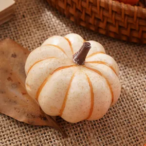 Primo piano di mini zucca artificiale in schiuma con dettagli crema e arancio