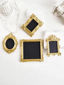 Detailansicht von vier goldenen Miniaturrahmen im Barockstil für die Fotografie.