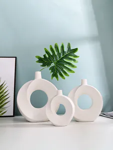 Set mit drei weißen minimalistischen Donut-Vasen aus Harz in einer modernen Umgebung