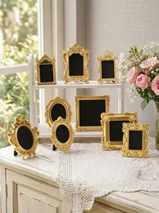 Group of vintage golden relief photo frames displayed on a rustic white table
