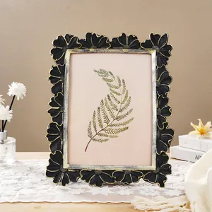 Detailed view of vintage black and gold daisy flower photo frame with 3D carving.