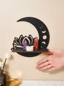 Hand showing scale of black wooden lotus moon wall shelf with crystals and candle
