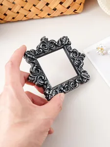 Detailed view of a vintage black and silver resin mini frame with ornate carvings for props